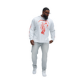 Man wearing slate grey jeans for men paired with white graphic long sleeve shirt and white sneakers