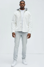 Man wearing slate grey jeans for men paired with white jacket and sneakers