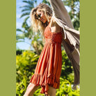 La Miel sleeveless summer dress in rust with a ruffled hem, perfect for warm days outdoors