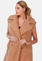 Woman wearing a brown teddy coat on a white background