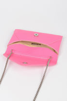 Inside view of a small black evening clutch bag featuring a stylish chain strap and snap closure
