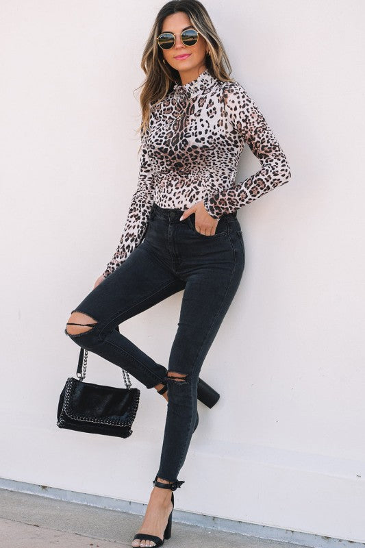 Stylish women's smocked neck long sleeve bodysuit in leopard print paired with ripped black jeans