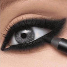 Close-up of applying smudge proof eyeliner for vacation on a model's eye with dramatic lashes