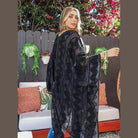 Chic woman wearing a soft open front kimono with a geometric pattern in a stylish outdoor setting