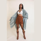 Stylish model wearing a soft open front kimono over a crop top with a brown skirt and western boots