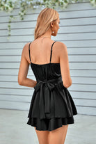 Back view of a black spaghetti strap layered romper with a stylish bow tie at the waist