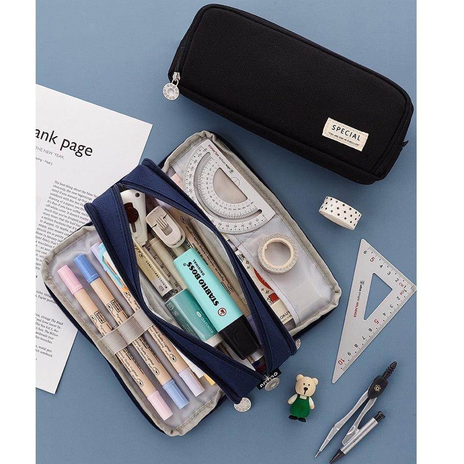 Dual side pencil case in black and navy with assorted stationery supplies organized inside