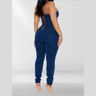 Back view of a strapless denim jumpsuit with lace-up detail and form-fitting design for women