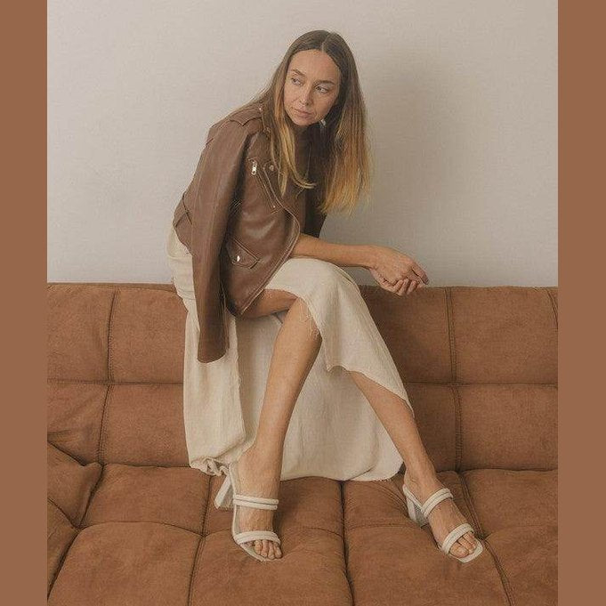 Stylish women's strappy alligator heel shoes paired with a chic outfit on a sofa