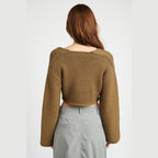 Back view of a stylish blue crop top by Emory Park with long sleeves and a relaxed fit