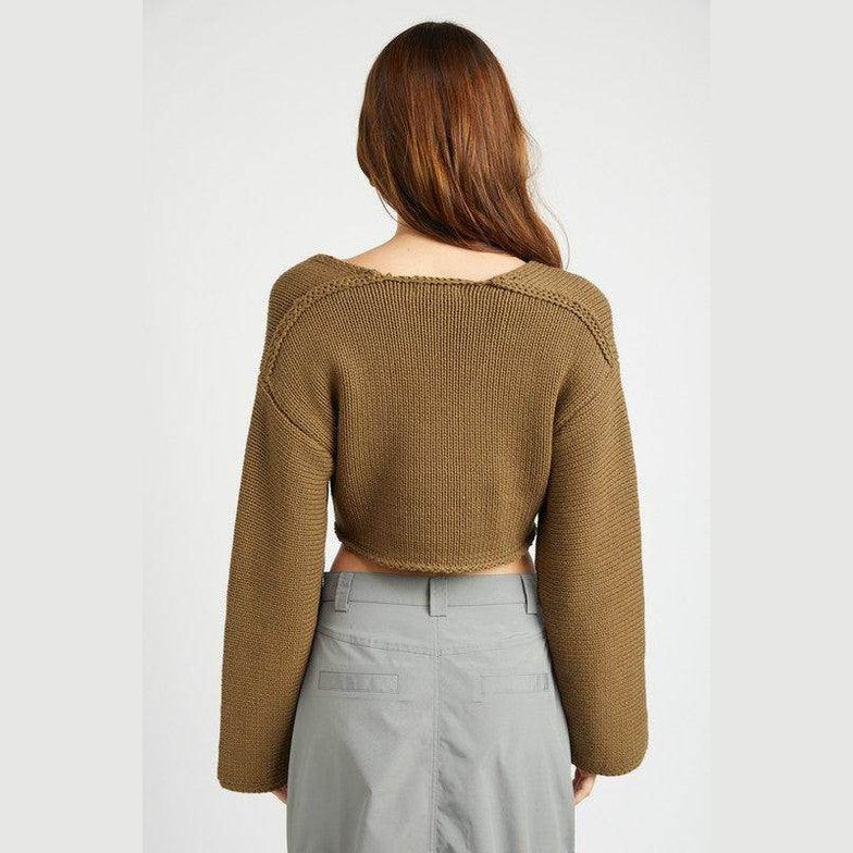 Back view of a stylish blue crop top by Emory Park with long sleeves and a relaxed fit