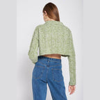 Back view of a stylish long sleeve crop shirt in green, paired with high-waisted jeans.