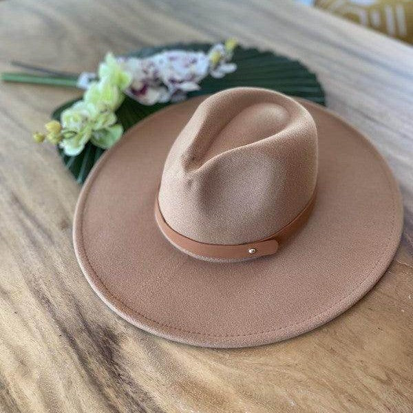 Queens, INC stylish panama hat in beige with a leather band on a wooden surface