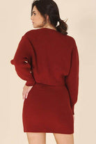 Women's stylish ribbed knit ensemble in red, featuring a cropped sweater and fitted skirt.
