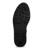 Underside view of stylish shearling collar boots with durable traction sole for women