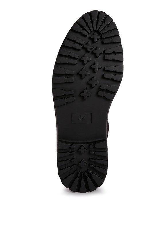 Underside view of stylish shearling collar boots with durable traction sole for women