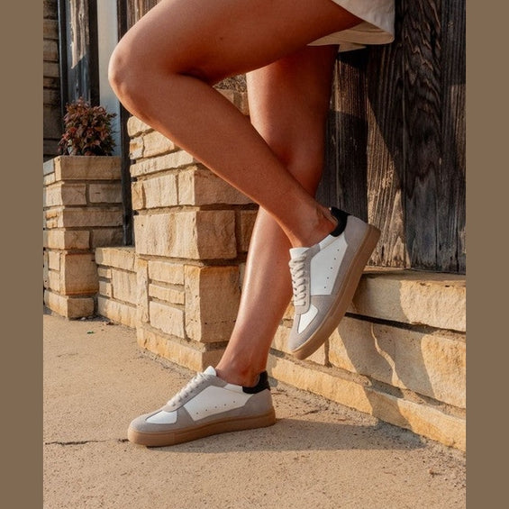 Maker's Shoes white and beige stylish sneakers for vacations worn by a woman outdoors