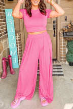 YNique stylish summer travel outfit women featuring pink crop top and wide leg pants with matching sandals