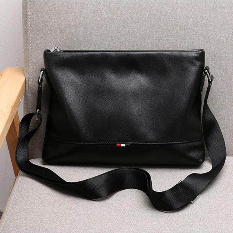 Stylish travel bag for men in black leather with a sleek design and adjustable shoulder strap