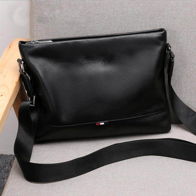 Stylish travel bag for men in sleek black leather with an adjustable shoulder strap