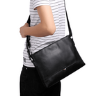 Stylish travel bag for men in black leather with adjustable strap, perfect for daily use