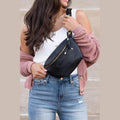 Woman holding a stylish travel waist pack in black, perfect for hands-free convenience while traveling