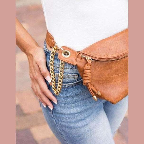 Stylish travel waist pack in tan leather with chain detail, perfect for on-the-go convenience