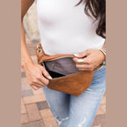 Aili's Corner stylish travel waist pack in tan being unzipped, showing ample storage for essentials
