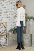 Women's stylish vacation blouse in white with bell sleeves paired with skinny jeans and ankle boots