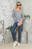 Stylish Vacation Tops Women featuring a grey off-shoulder shirt paired with jeans and a clutch