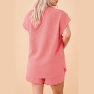 Back view of woman wearing pink textured summer casual drawstring shorts outfit by SHEWIN INC