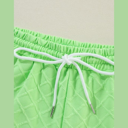 Close-up of green summer casual drawstring shorts outfit with textured fabric and white drawstring