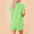 Back view of woman wearing bright green summer casual drawstring shorts outfit by SHEWIN INC.
