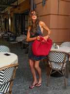 Women's navy floral dress for the summer with a red tote bag