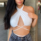 Woman wearing white summer push up bandeau top with crisscross straps paired with denim shorts