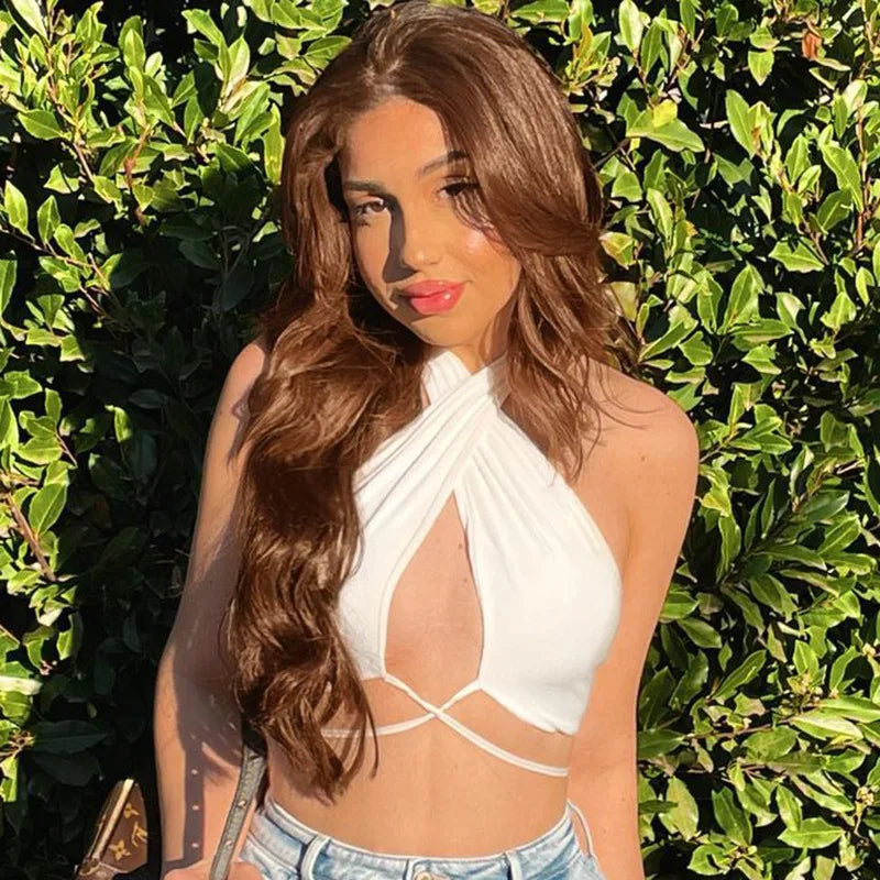 Woman wearing a white summer push up bandeau top with crossover straps outdoors in sunlight