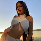 Woman wearing a white summer push up bandeau top with cross front design at sunset