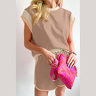 YNIQUE summer vacation two piece outfit in beige with matching shorts and top holding a pink bag