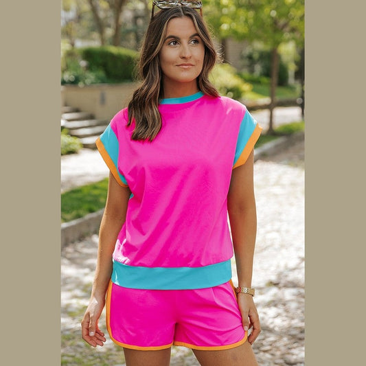 YNIQUE bright pink summer vacation two piece outfit with blue and orange trim on a woman