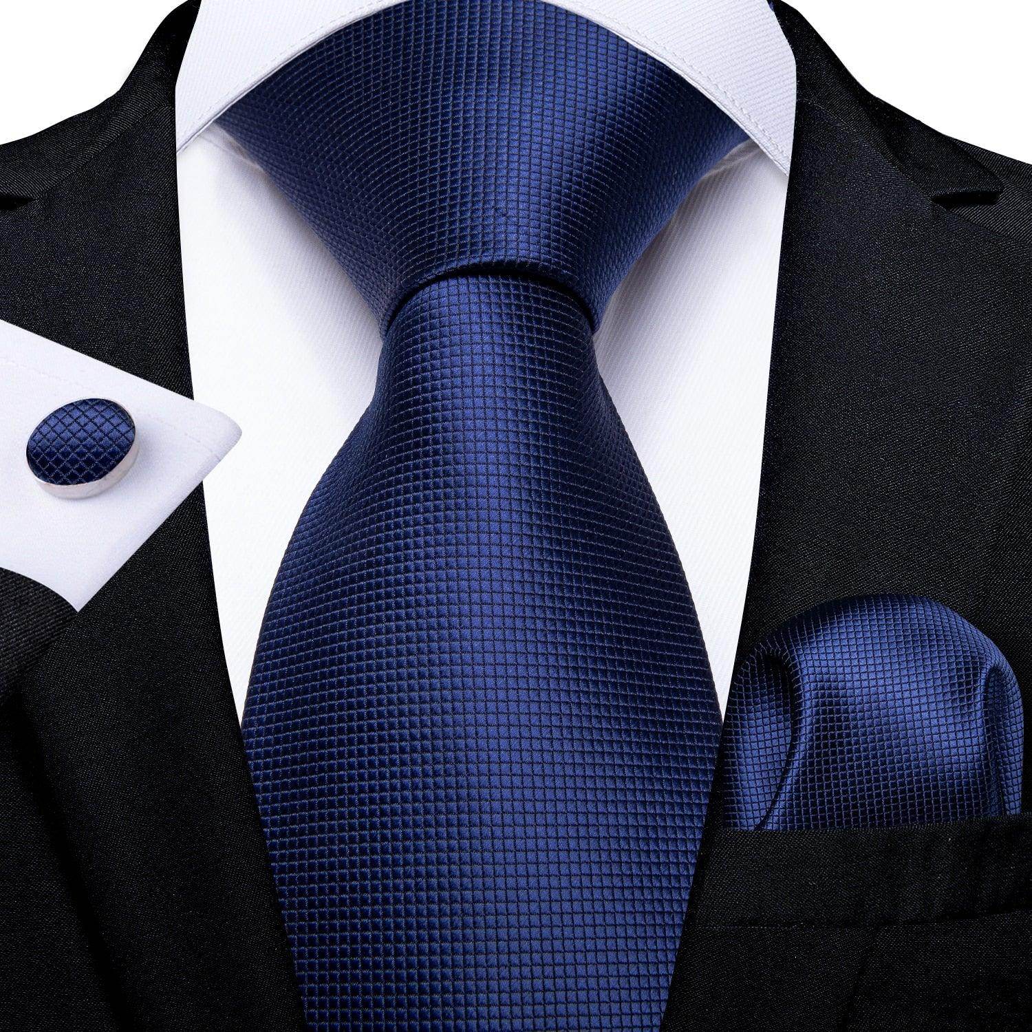 Teal blue paisley necktie displayed with a matching pocket square and cufflinks for stylish men's accessories