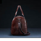Textured leather travel bag in dark brown with sturdy handles and a detachable strap for easy carrying