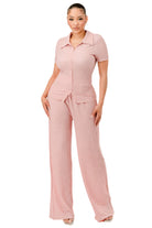 Women wearing textured pink pants set with short sleeves and collared top by VacationGrabs