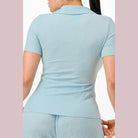 Light blue textured polo set for women showing back view short sleeves and collar