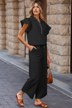 Stylish women's textured ruffle lounge set in black featuring a zip-up top and wide-leg pants