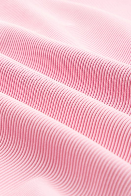 Close-up of pink fabric showcasing texture of the textured ruffle lounge set by JUNIPER BLVD