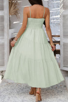 Light green tiered cami vacation dress featuring a smocked bodice and flowy skirt for summer outings