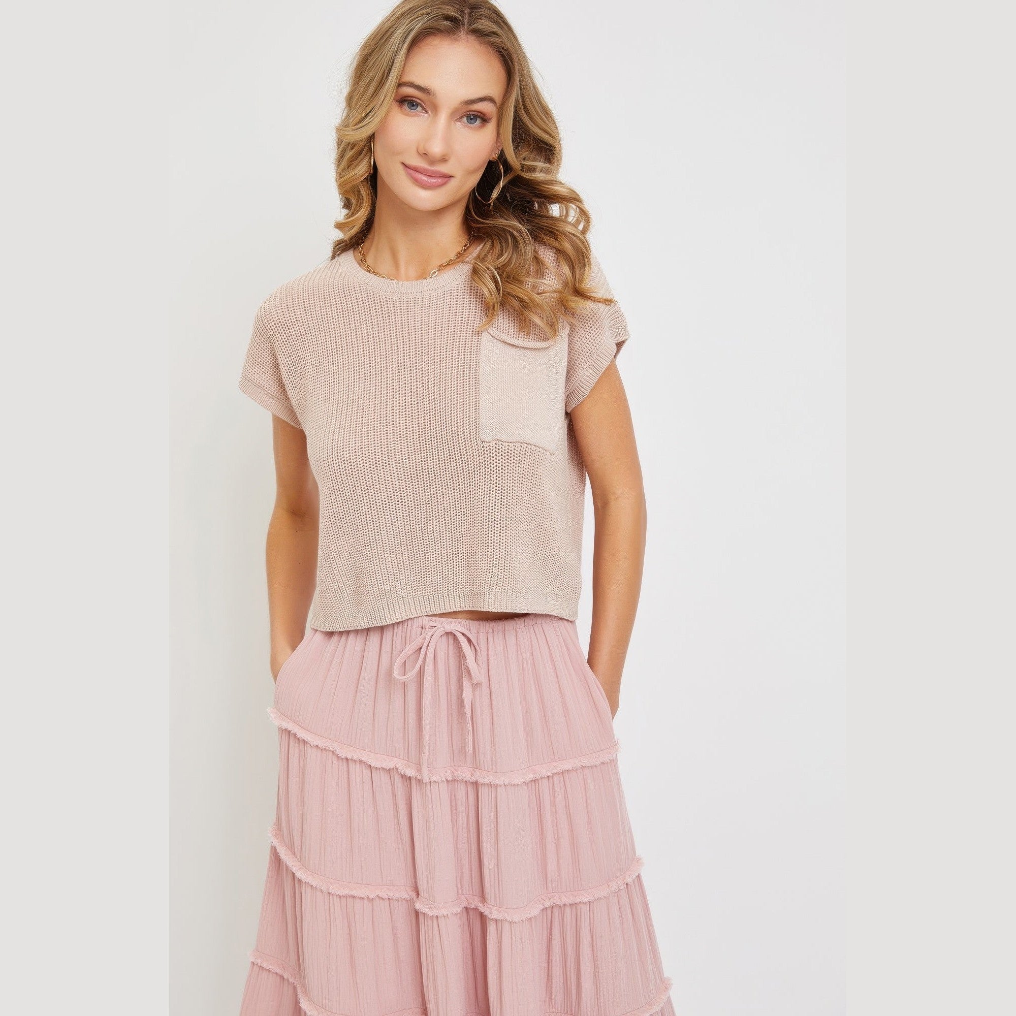 Woman wearing a pink tiered maxi skirt for women paired with a beige short sleeve top