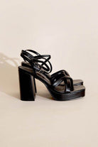 Stylish black cross ankle strap heels with a chunky heel for fashionable women