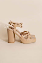 Beige cross ankle strap heels by Top Guy Footwear with chunky heels for a stylish look