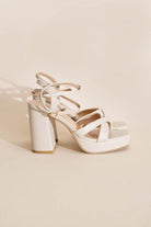 Stylish white cross ankle strap heels with chunky high heel and platform for elegance and comfort